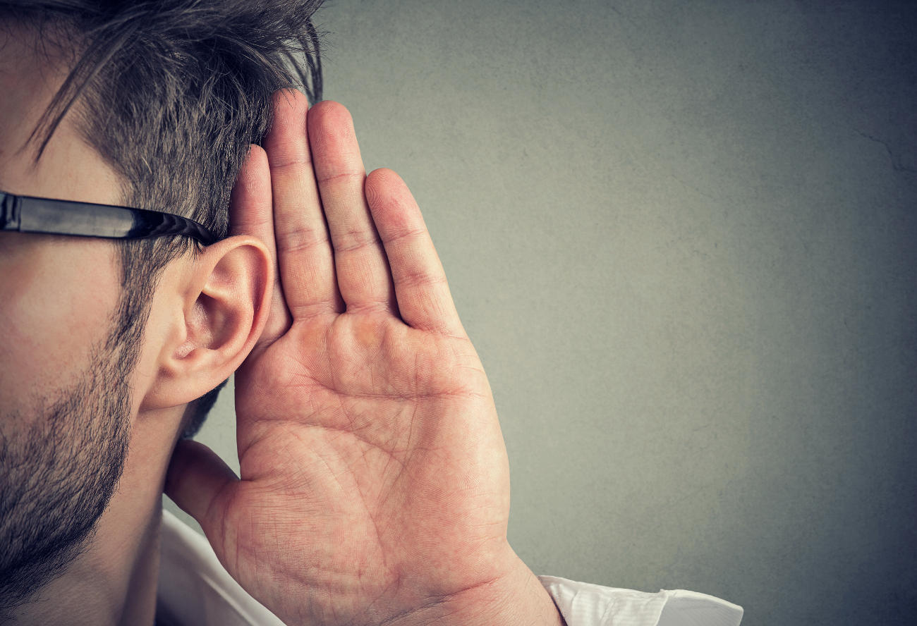 Stylish close-up of a man holding his hand up to his ear.